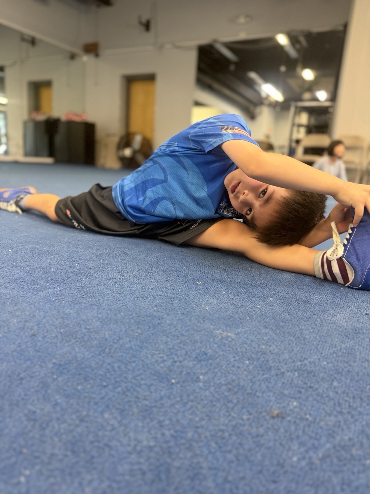 A student stretches into the splits